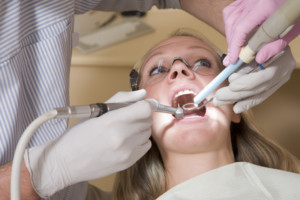 Tandläkare/tandhygienist behandlar kvinna.